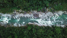 Suspension Bridge Over Rio Cangrejal River In Pico Bonito National Park. Top Down Aerial Drone View. High Up. Tourists On Bridge Over Rushing River. Moody Low Light With Dark Colors.