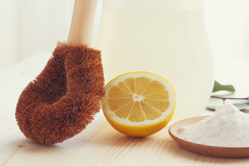 eco-friendly natural cleaning products, bamboo brush, lemon, baking soda (sodium bicarbonate) on wooden table, go green, zero waste lifestyle