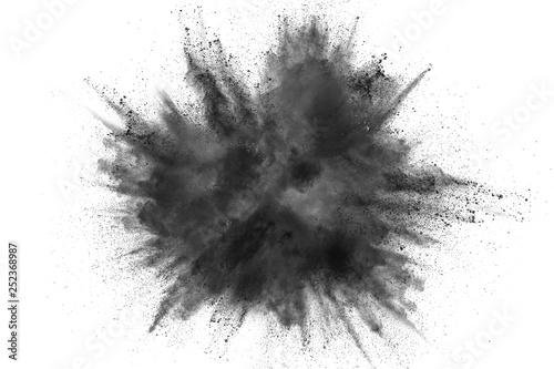 Black powder explosion against white background. Charcoal dust particles exha...