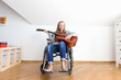 © AnastazjaSoroka - Young disabled woman playing the guitar.