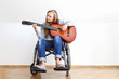© AnastazjaSoroka - Disabled young woman in wheelchair playing the guitar.