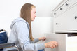 © AnastazjaSoroka - Young disabled woman in  wheelchair opens drawers in the dresser.