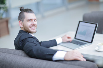 Wall Mural - portrait of a smiling businessman sitting at a Desk.