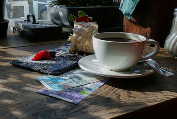 Wall Mural - Kuwaiti banknotes lying under a cup of coffee 