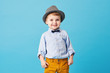 © oes - Portrait of happy joyful  little boy isolated on blue background. Toddler child in hat and fashionable suit smiling and have a fun