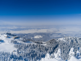 Winter mountains landscape, view from Postavaru peak (1799 m high) in Brasov, Romania, with Bucegi and Fagaras mountains in the background.