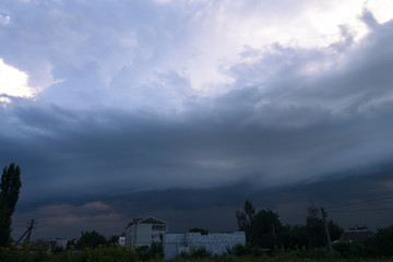 Wall Mural - Scary epic sky with menacing clouds. Hurricane wind with a thunderstorm. Stock background, photo