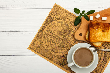 Wall Mural - A cup of coffee, fresh bread, toast on a white woody background. Morning breakfast fresh bread with a cup of coffee. View from above.