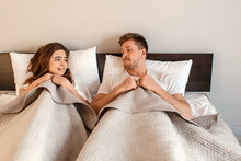 Young Couple In The Bed. Fear Of Sex, Shy Woman And Man Hidding Under Blanket Before Intimacy
