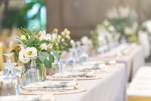 Setting Of Tables For Wedding Celebration Dinner With A White Bouquet And Beautiful Flower.