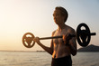 © Love You Stock - man with barbell on beach at sunset. health and sport concept.