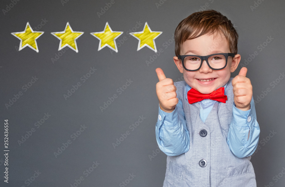 Cute little boy giving thumbs up with 4 stars approved Stock Photo ...