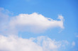 Altocumulus, stratocumulus and cumulus fluffy clouds on light clear blue sky background.