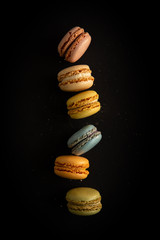 Wall Mural - Colorful macaron cookies stacked on a black background