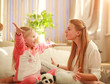 © okostia - Young mother and daughter are having fun playing at home, happy parenting and family leisure