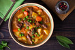 © freeskyline - Homemade Irish beef stew with potatoes, carrots and peas in bowl on wooden table. overhead, horizontal