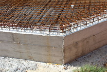 Concrete Building Foundation With Densely Laid Rusted Metal Construction Net On Top Of Insulation At Local Building Construction Site On Warm Sunny Day