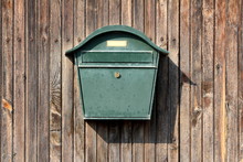 Dark Green Metal Vintage Retro Mailbox With Lock Mounted On Wooden Boards Barn Wall On Warm Sunny Day