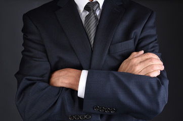 Wall Mural - Closeup of a man in a gray business suit with his arms crossed