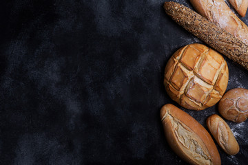 Fresh bread on a black chalkboard. Top view with copy space