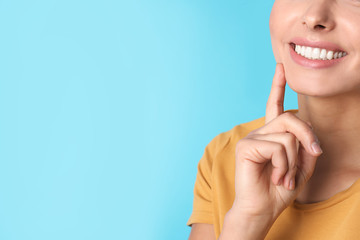 Wall Mural - Young woman with healthy teeth on color background, closeup. Space for text