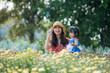 © ratiratzaz - Mother and daughter blowing bubbles in the flower garden