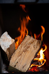 birning wood with flames in fireplace