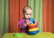 © Maksym - the kid enthusiastically collects a multi-colored pyramid