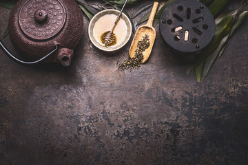 Wall Mural - Traditional Asian green tea background with black iron teapot, candle and honey on dark rustic background with copy space, top view