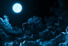 Bright Full Moon In The Mystical Midnight Sky With Stars Surrounded By Dramatic Clouds. Dark Natural Background With Night Sky With Moon And Clouds