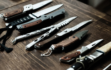 many different knives on a wooden surface