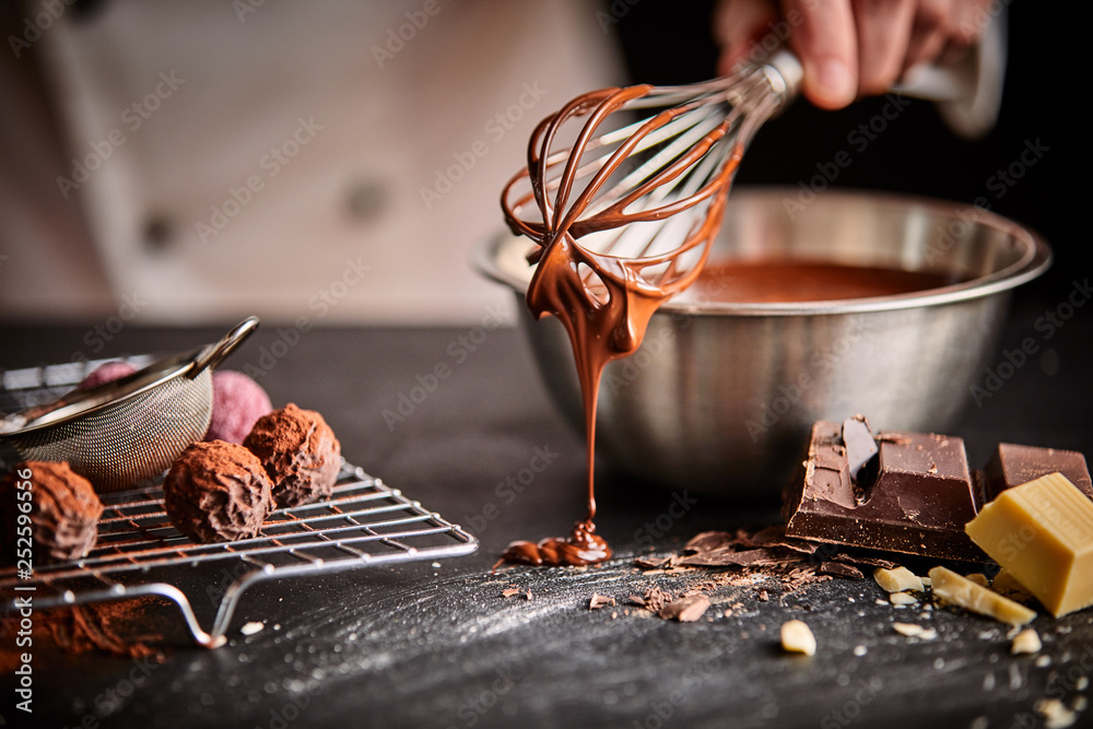 Baker or chocolatier preparing chocolate bonbons - obrazy, fototapety, plakaty 