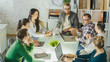 © Gorodenkoff - Group of Young Creative People Have Strategic Planning Session. They are Sitting at Big Glass Table with Open Laptops in their Bright and Modern Loft Office.