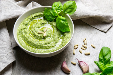 bowl of fresh basil pesto with pine nuts and garlic cloves