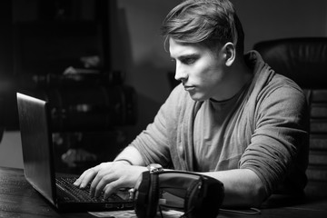 Poster - a young man works at the computer. remote work. a man works through the internet.