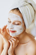 © Olesia - Beautiful young woman with facial mask on her face. Skin care and treatment, spa, natural beauty and cosmetology concept.
