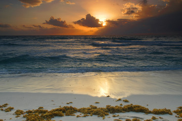 Wall Mural - sunrise with light from behind the cloud and reflection in the ocean