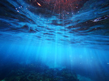 Underwater Background Deep Blue Sea And Beautiful Light Rays With Sandy Floor
