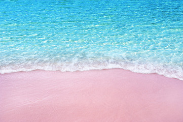 Soft blue ocean wave on pink sandy beach