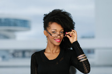 Young cheerful urban stylish businesswoman wearing glasses.