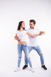 © satura_ - Young couple dancing social latin dance bachata, merengue, salsa. Two elegance pose on white background