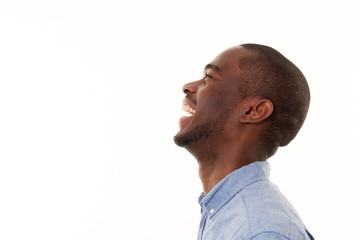 Wall Mural - profile portrait of handsome young black man laughing against isolated white background