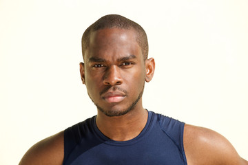 Wall Mural - Front portrait of serious young black man against white background staring