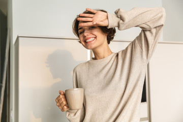 Canvas Print - Smiling young woman having cup of tea