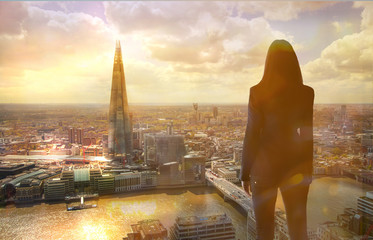 Sticker - Young woman looking over the City of London at sun set. Future, new business opportunity and business success concept.