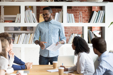 Diverse businesspeople gathered together at seminar in modern office