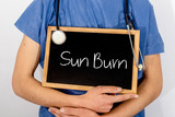 Fototapeta  - Doctor shows information on blackboard: sun burn.  Medical concept.