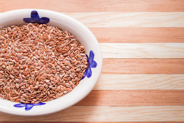 Wall Mural - flaxseed grains in bowl on wooden