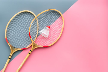 Wall Mural - Badminton equipment. Badminton rackets and shuttlecock on pink and grey background top view copy space