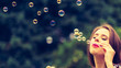 © Voyagerix - Woman blowing soap bubbles, having fun